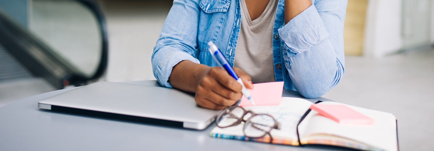 Woman writing notes in book